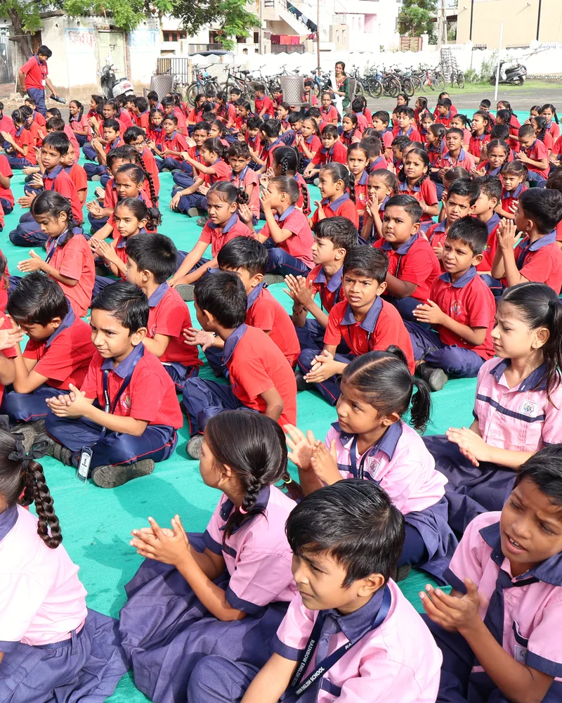 Students clapping at an outdoor school assembly