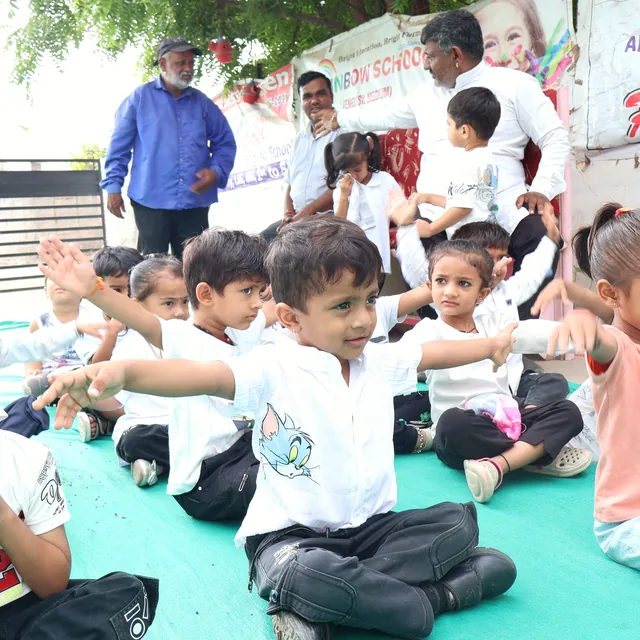 Nursery children learning a yoga stretch outdoors