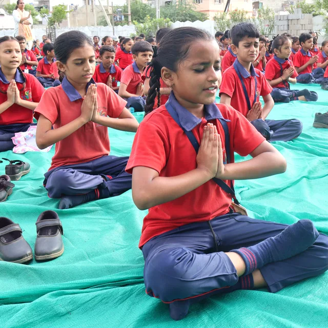 Students practising yoga on the school ground